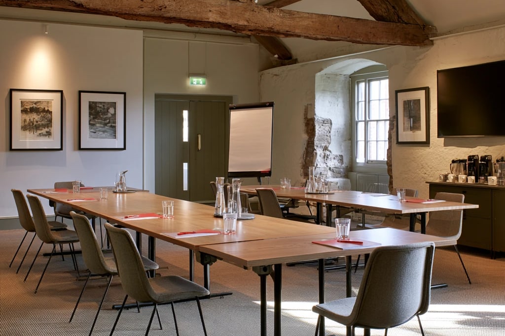 The Counting House set for a meeting, with tables in a U shape under oak beams